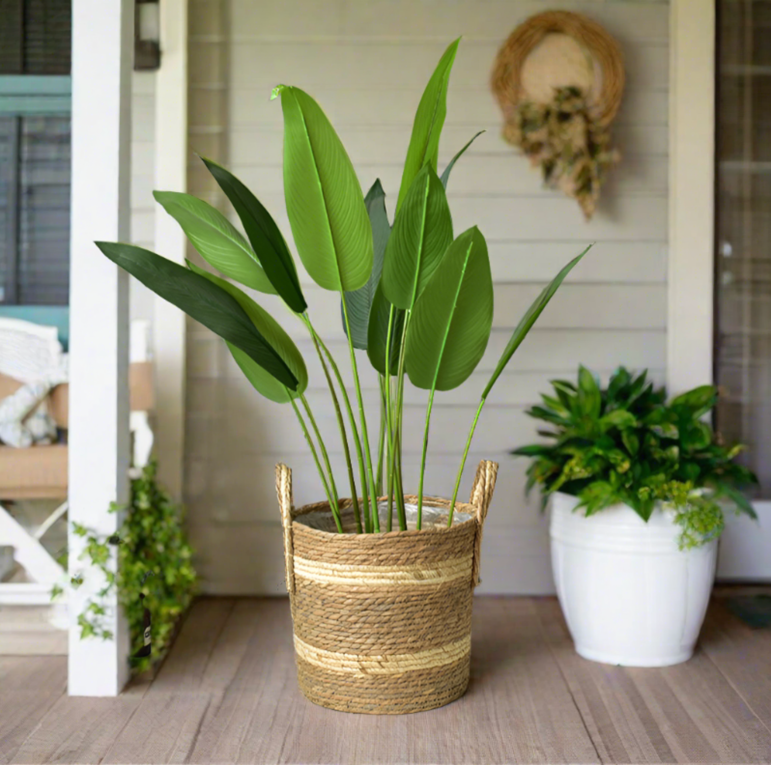 Woven plant basket with handles, featuring natural straw and cream stripes. Home decor accent.